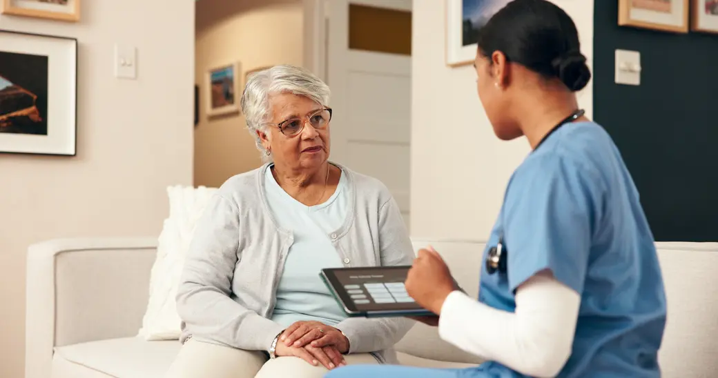 Seniorin und Krankenschwester in einem Gespräch.
